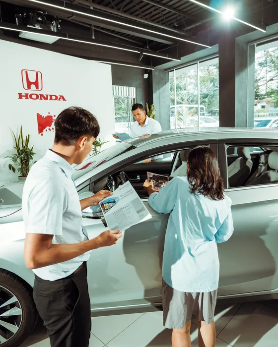 A couple looking over a car with a salesperson in a showroom